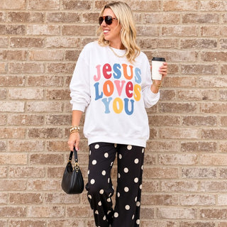 Woman wearing the Jesus Loves You Christian sweatshirt in White with black polka dot pants