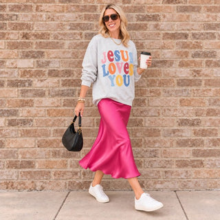Jesus Loves You faith sweatshirt in Ash gray styled with a pink satin skirt and white sneakers