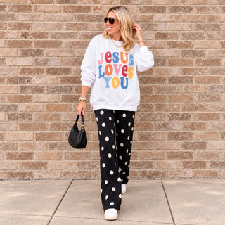 Jesus Loves You faith sweatshirt in White styled with polka dot pants and a black handbag