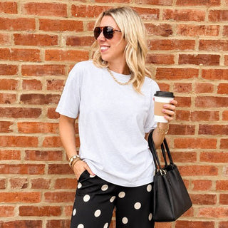 Woman wearing the Favorite Soft Solid Bella+Canvas Tee in Ash with black polka dot pants