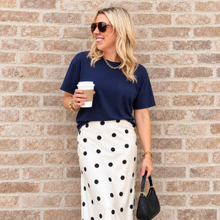 Woman wearing the Favorite Soft Solid Bella+Canvas Tee in Navy with a polka dot satin skirt